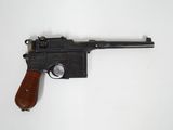 un vieux pistolet avec une poignée en bois sur une surface blanche
