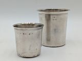 une paire de tasses argentées sur fond blanc