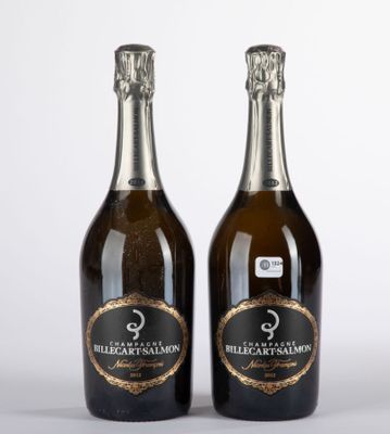 deux bouteilles de champagne posées l'une à côté de l'autre sur une surface blanche