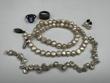 a white pearl necklace and bracelet with a ring on it