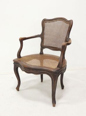 une image représentant une chaise en bois avec un dossier et une assise en rotin