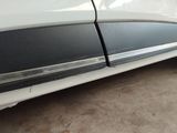 a close up of a white car with a black stripe on the side