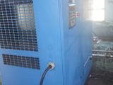 un sécheur d'air industriel installé dans un entrepôt, auquel est raccordé un tuyau