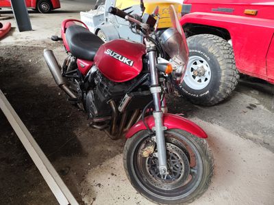 une moto rouge garée sur un parking à côté d'un camion rouge