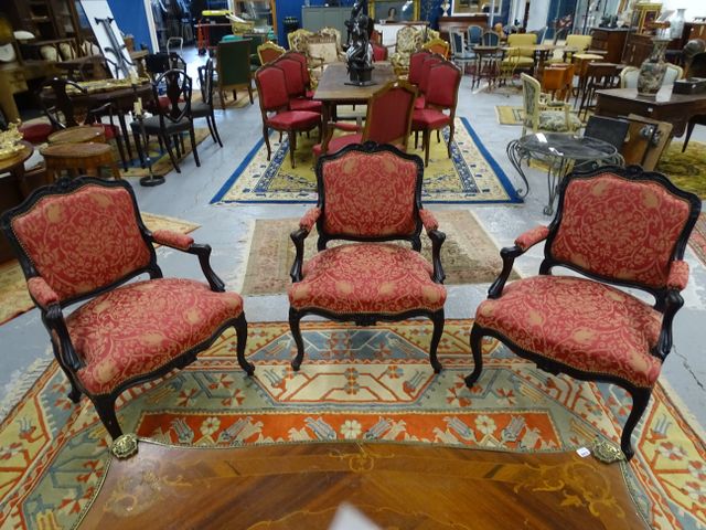 Suite de trois fauteuils à la reine en bois noirci garnis de tiss...