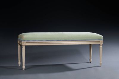 an upholstered bench with a green upholstered cushion