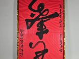 un tableau rouge et noir avec des caractères chinois sur un mur blanc