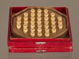une boîte rouge contenant un tas de perles en bois