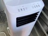 un climatiseur blanc posé à l'intérieur d'un réfrigérateur ouvert