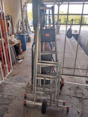 a picture of a ladder in a garage with a lot of tools