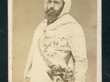 une vieille photo d'un homme barbu vêtu d'une tenue blanche