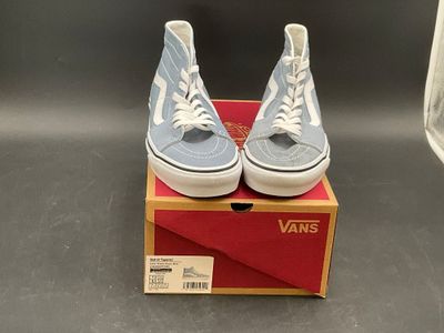 blue and white vans sneakers in a box on a table