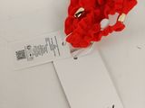 two red crocheted flowers are on a white table