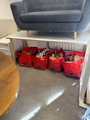 a couch and a table in a room with red bags on the floor