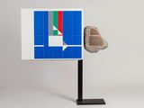 a sculpture of a rock on a stand with a flag on it