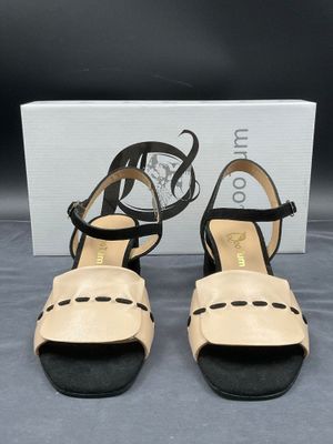 une paire de sandales pour femme, noires et beiges, avec des lanières noires