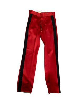 Le pantalon est rouge et noir, avec des rayures noires.