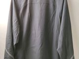 the back of a jacket hanging on a hanger against a wall