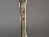 an old silver spoon sitting on top of a wooden table
