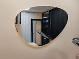 a round mirror on the wall in the bathroom