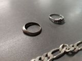 a silver ring and a silver chain on a table