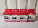 four canon ink cartridges are sitting on a table next to each other