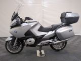 a picture of a silver motorcycle parked on a black and white checkered floor