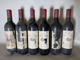 six bottles of wine are lined up in a row on a table