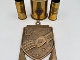 un ensemble d'objets en laiton comprenant un décapsuleur en laiton, un porte-verre en laiton et une assiette en laiton