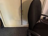 une chaise de bureau noire assise devant un bureau d'ordinateur