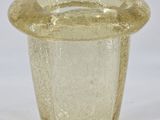 a glass vase with a lid on a white surface