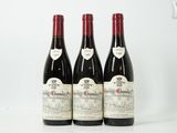 trois bouteilles de vin rouge posées sur une table blanche