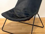 black leather butterfly chair with black metal frame on wooden floor