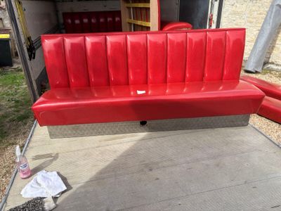 a red bench that is sitting in the back of a truck
