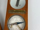 a wooden clock with a compass on top of it