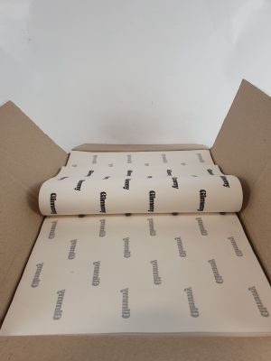 une boîte en carton ouverte sur laquelle est posé un rouleau de papier
