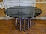 a glass table with a metal base in a room