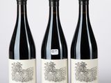 trois bouteilles de vin posées sur une table blanche