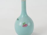 a small blue vase with a pink flower on it