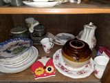 many plates and cups on a shelf in a cabinet