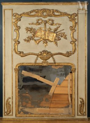 un miroir avec un cadre doré et une croix dessus