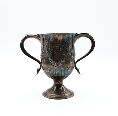a silver cup that is sitting on a white surface