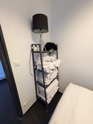 une photo d'une chambre à coucher avec un lit et une lampe