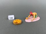 a miniature figurine of a man and a bowl of corn