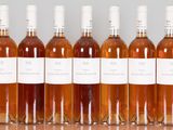 six bottles of wine are lined up in a row on a table