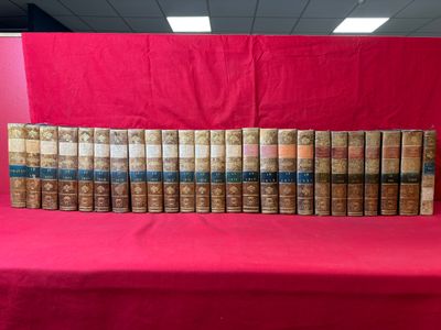 une pile de vieux livres posée sur une table rouge