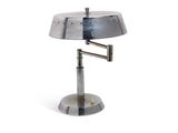 a metal lamp that is on a stand on a white surface