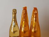 trois bouteilles de champagne posées côte à côte sur une table