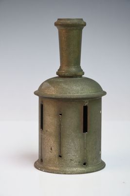 un petit vase vert posé sur une table blanche