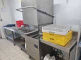 une cuisine équipée d'un évier et d'un plan de travail sur lequel sont posés des paniers
